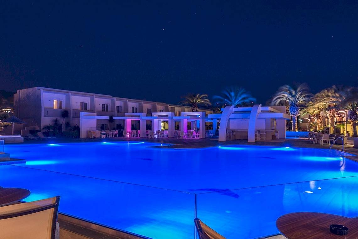 Pool des Sandy Beach Hotels in Kos bei Nacht mit blauer Beleuchtung und Palmen