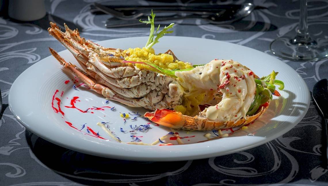 Essen im Atrium Platinum Luxury Resort Hotel & Spa, ein Hummergericht mit Garnelen und Beilagen.