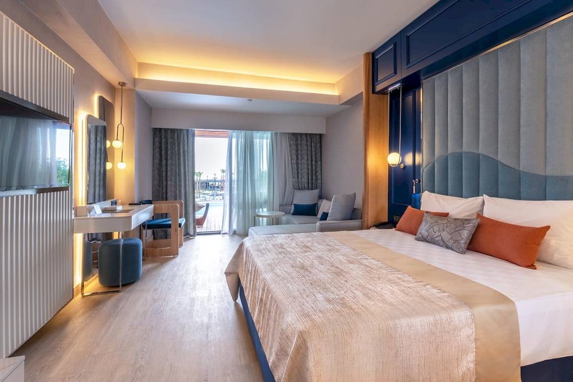 Innenansicht des Lago Hotels, Bett und Wohnzimmerbereich sichtbar