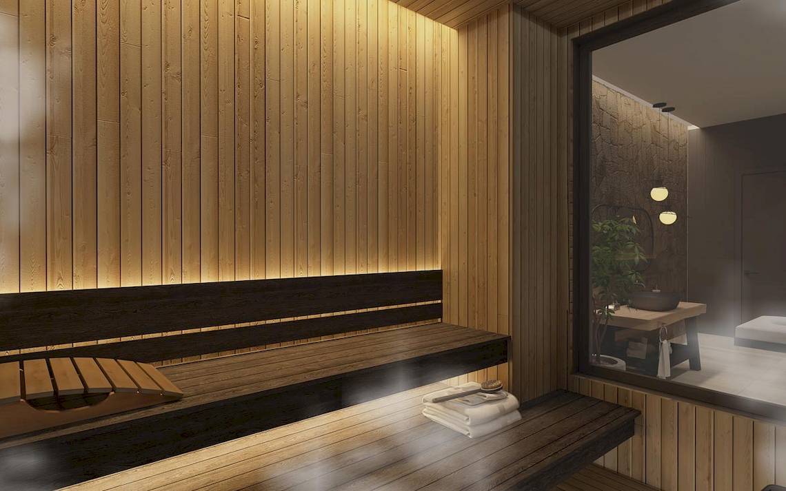 Innenansicht der Sauna im Lago Hotel mit Holzwänden und Bänken, Beleuchtung und einem Fenster.