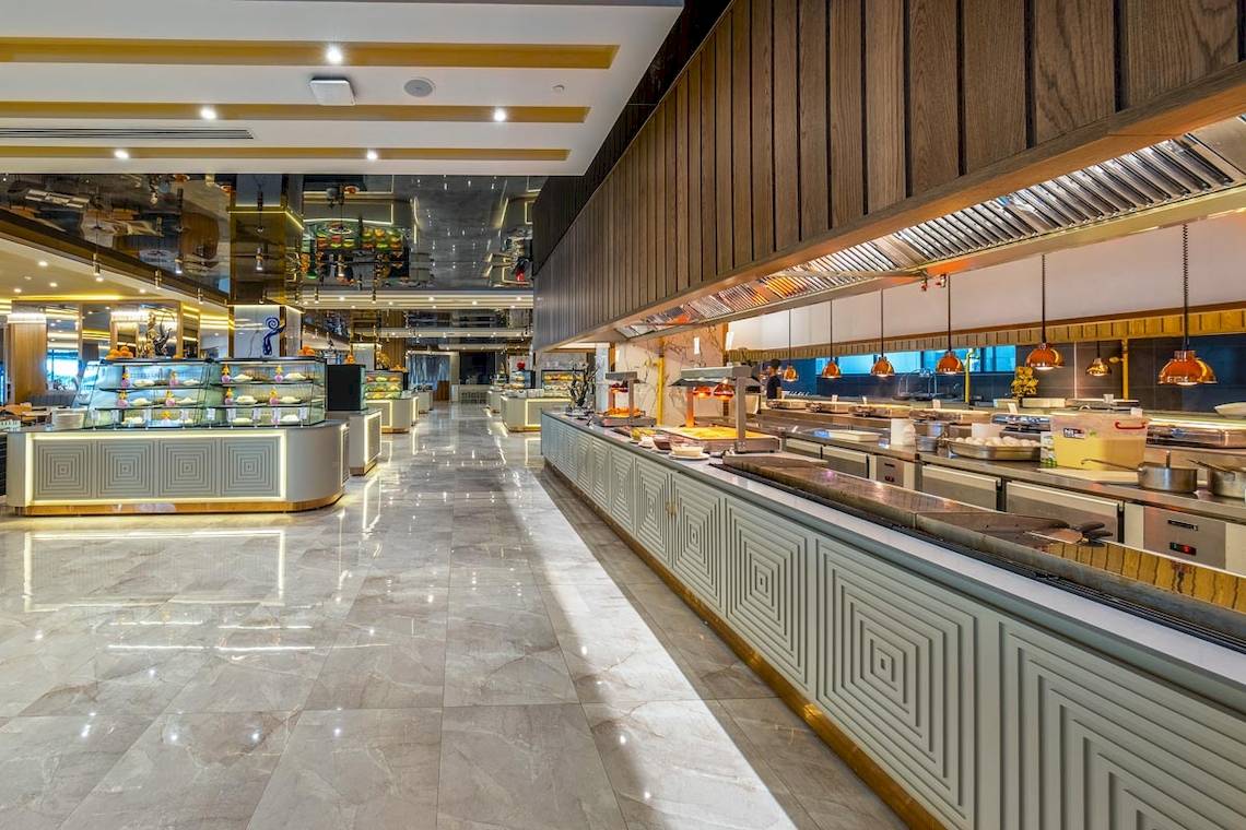 Innenansicht des Restaurants im Lago Hotel mit geometrischen Mustern, Marmorböden und bereitem Essen.