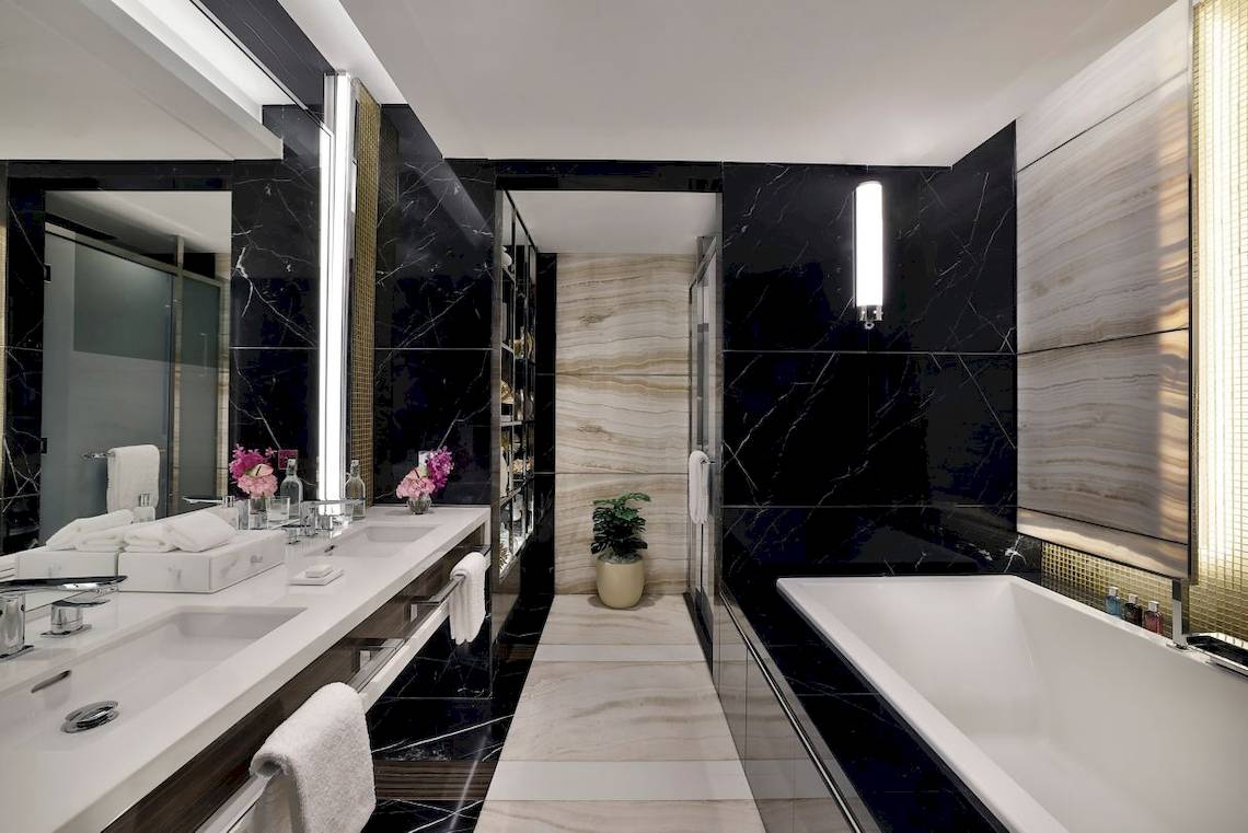Badezimmer im Marriott Resort Palm Jumeirah, Dubai, mit schwarzen Marmorwänden und weißen Oberflächen.