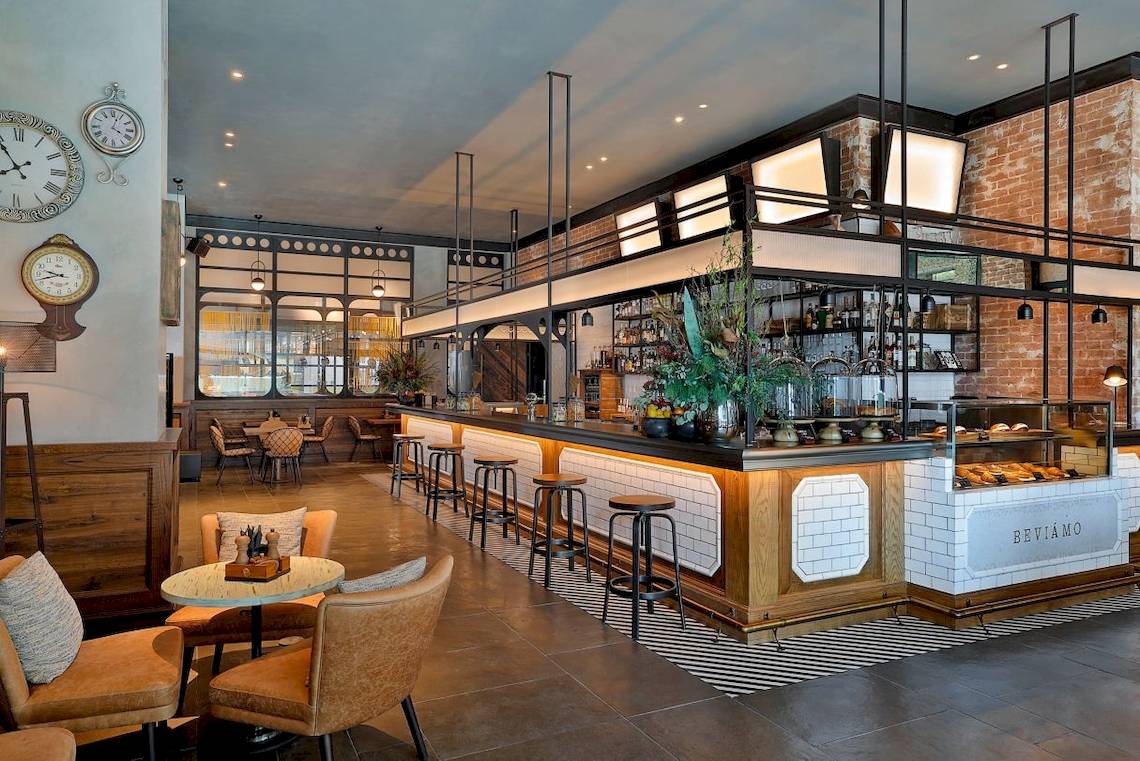 Innenansicht des Restaurants im Marriott Resort Palm Jumeirah, Dubai, mit Theke, Stühlen und Tischen.