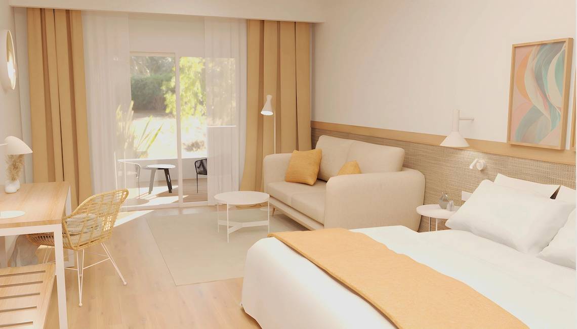 Modernes Hotelzimmer im Sunscape Dominicus La Romana mit Bett, Couch, Tisch und Zugang zu Terrasse.