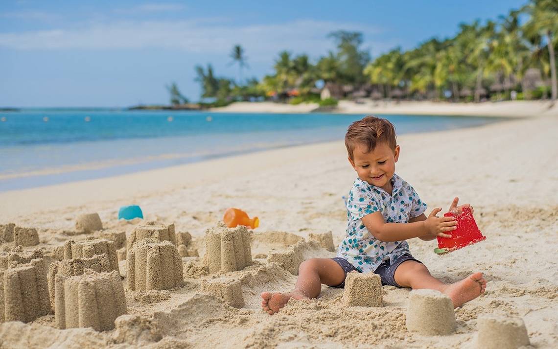 Kleiner Junge baut Sandburg am Strand des Constance Ephelia Mahe Seychelles