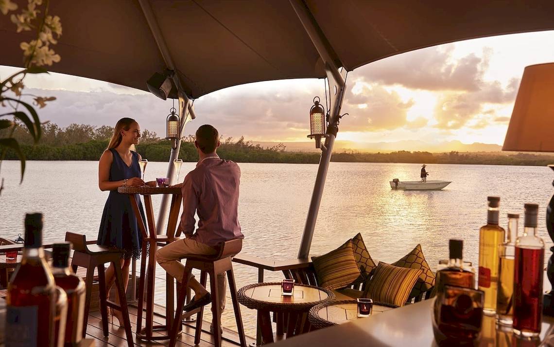 Paar auf der Terrasse des Constance Ephelia Mahe Seychelles mit Blick auf das Meer und Sonnenuntergang