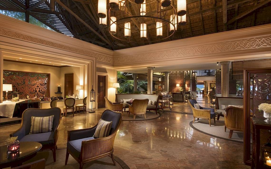 Lobby des Constance Ephelia Mahe Seychelles Hotels mit Sitzmöbeln und Kronleuchter.