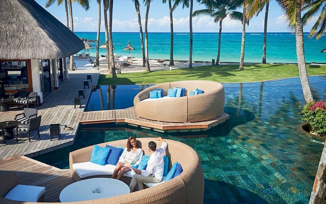Paar im Constance Ephelia Mahe Seychelles am Infinity-Pool mit Blick auf den Strand.