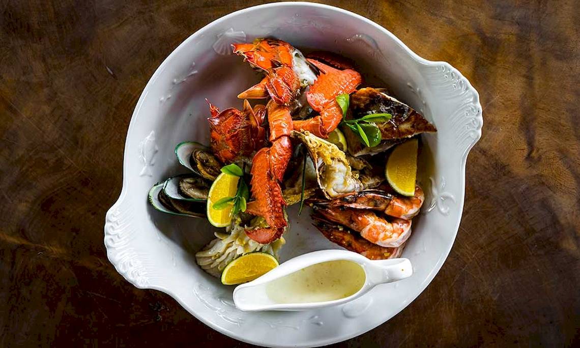 Eine Schale mit verschiedenen Meeresfrüchten wie Hummer, Garnelen und Muscheln.