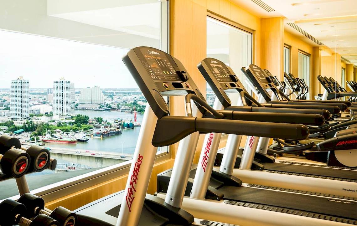Fitnessstudio mit Laufbändern und Ausblick auf Thailand