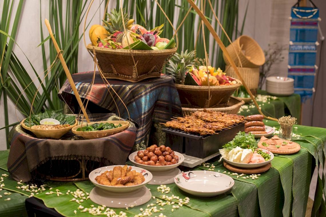 Buffet-Tisch im Novotel Bangkok Sukhumvit 20 mit verschiedenen Gerichten und Früchten.