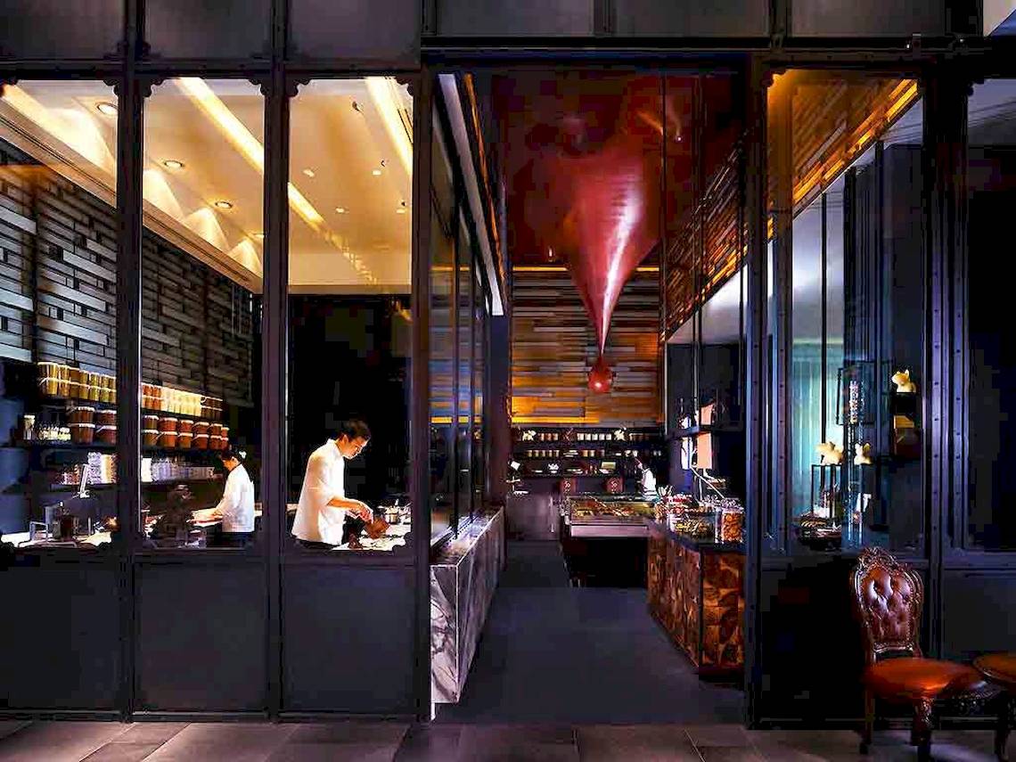 Inneneinrichtung des Restaurants im SO/ Bangkok Hotel mit zwei Köchen und einem roten Designelement.
