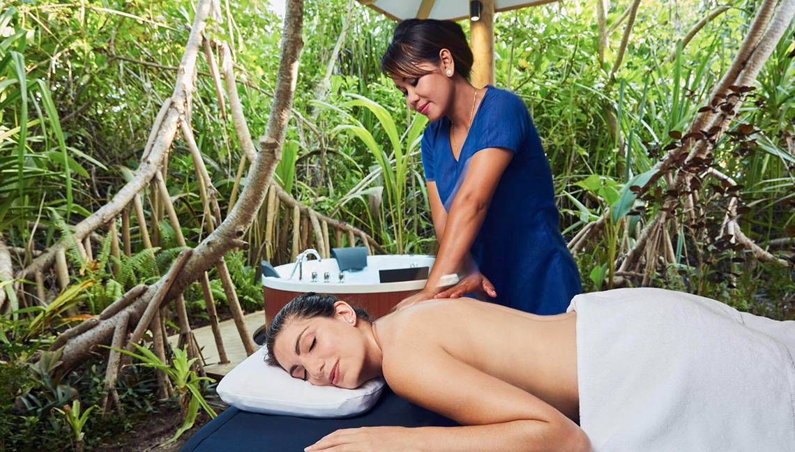 Frau im Amari Havodda Maldives Hotel genießt eine Massage im Freien