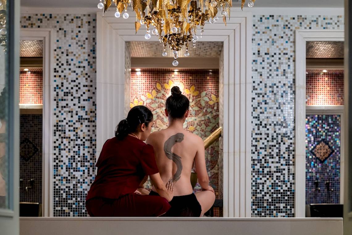 Massagebehandlung im Amatara Welleisure Resort mit einer Therapeutin, die das Rücken eines Kunden bearbeitet.