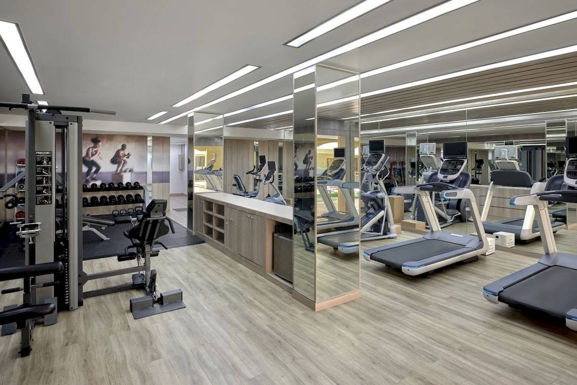 Fitnessstudio im Phuket Marriott Resort & Spa mit Trainingsgeräten und Spiegeln.