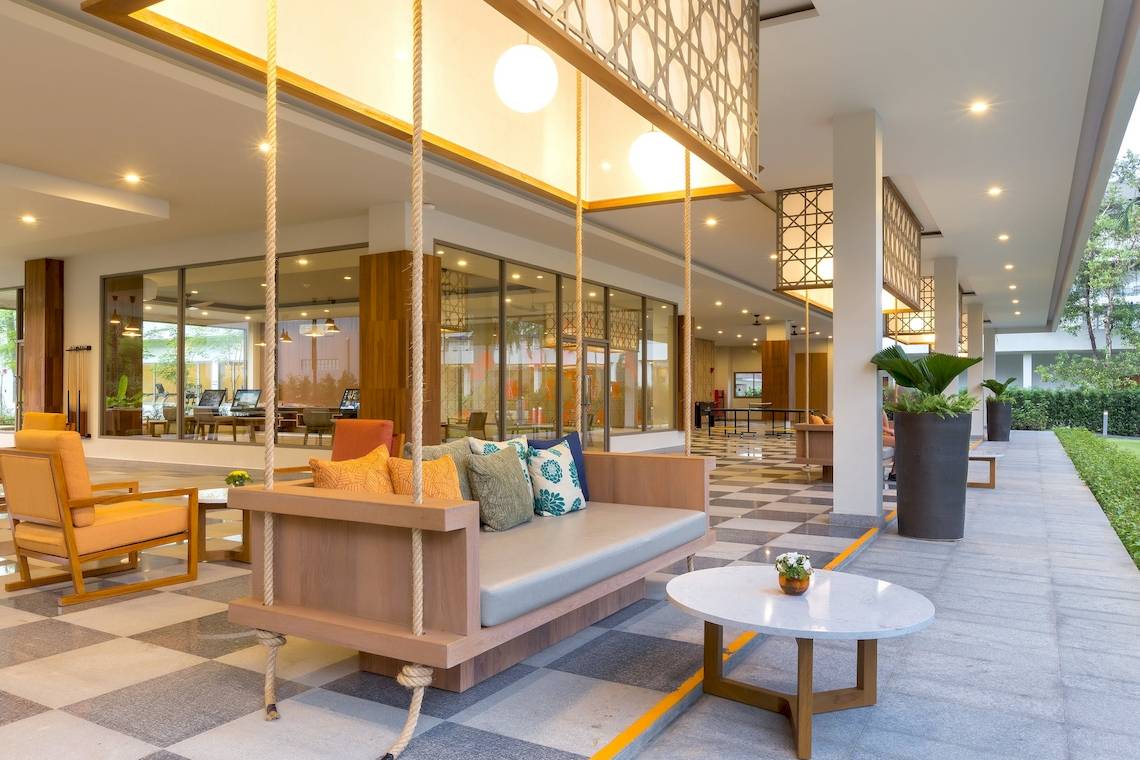 Eingangsbereich des X10 Khaolak Resorts mit einem Sofa und einem Tisch.
