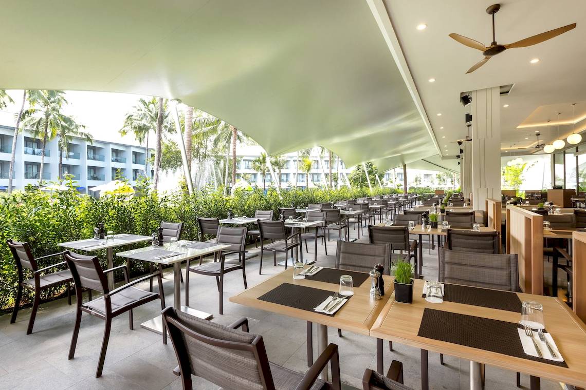 Innenansicht des Restaurants im X10 Khaolak Resort mit vielen Tischen und Stühlen.