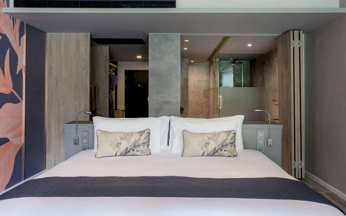 Schlafzimmer im La Flora Khao Lak Hotel mit großem Bett und modernen Möbeln.