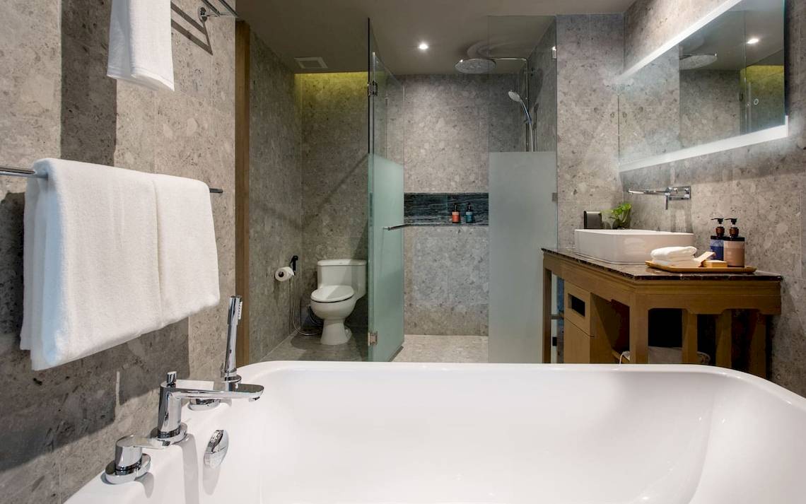 Badezimmer im La Flora Khao Lak Hotel mit Badewanne, Dusche und Waschtisch.