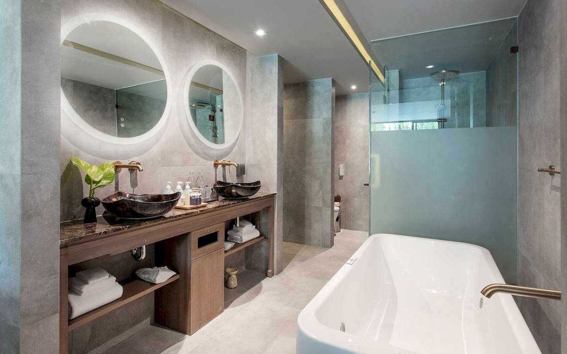 Ein modernes Badezimmer von La Flora Khao Lak mit zwei Waschbecken und einer Badewanne.
