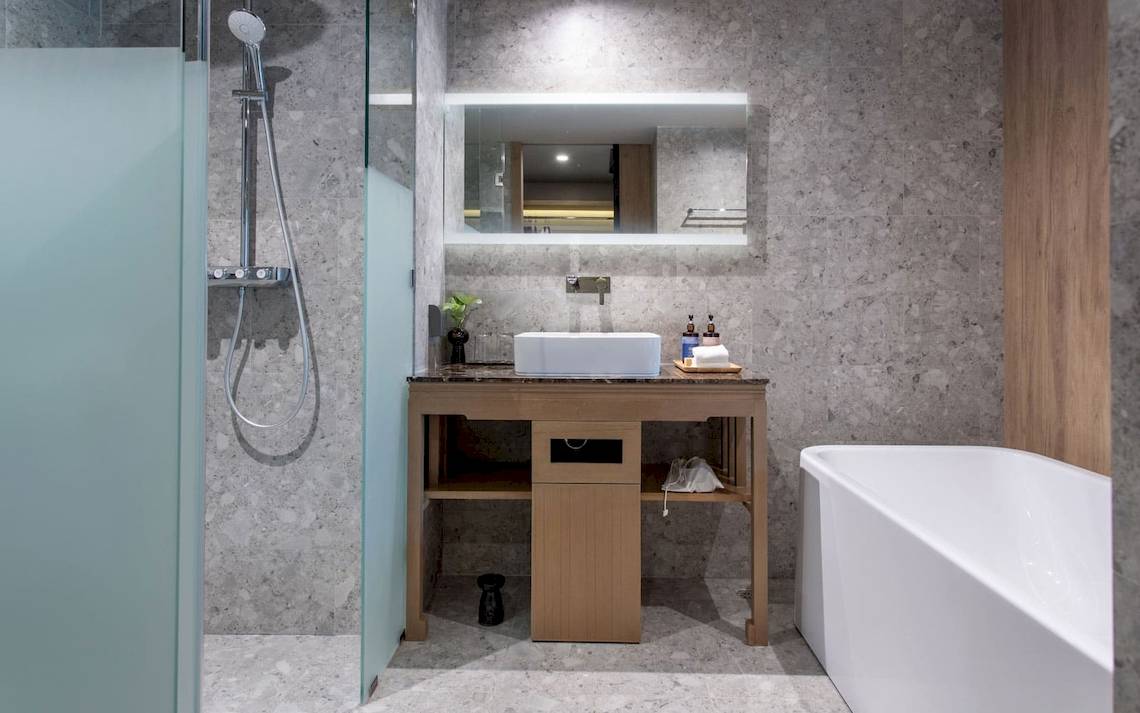 Badezimmer im La Flora Khao Lak Hotel mit Dusche, Waschbecken und Badewanne.