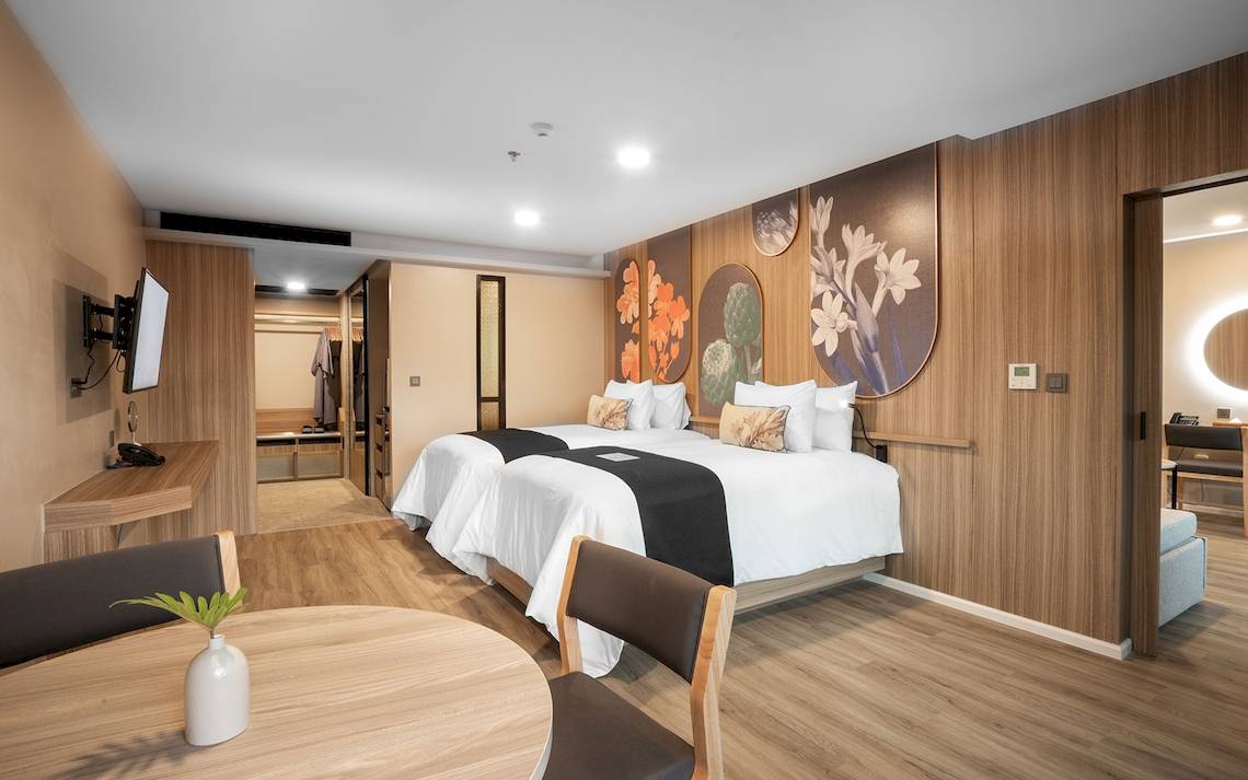 Innenansicht eines Hotelzimmers im La Flora Khao Lak mit zwei Betten und modernem Interieur.
