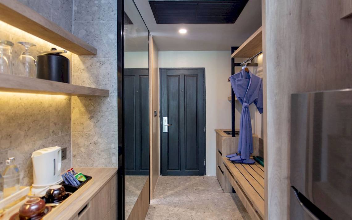 Suite Eingangsbereich im La Flora Khao Lak Hotel mit moderner Einrichtung und blauem Bademantel