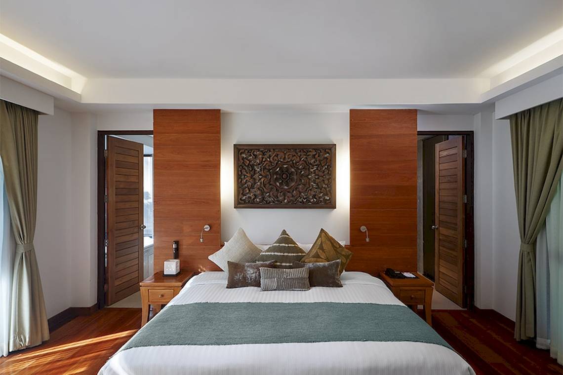 Innenansicht eines Zimmers im Khaolak Paradise Resort mit Doppelbett und Dekor.