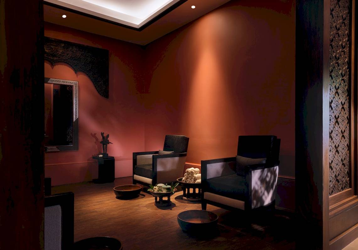 Spa-Raum im Santiburi Koh Samui Hotel mit zwei Sesseln, Töpfen und einem Spiegel.