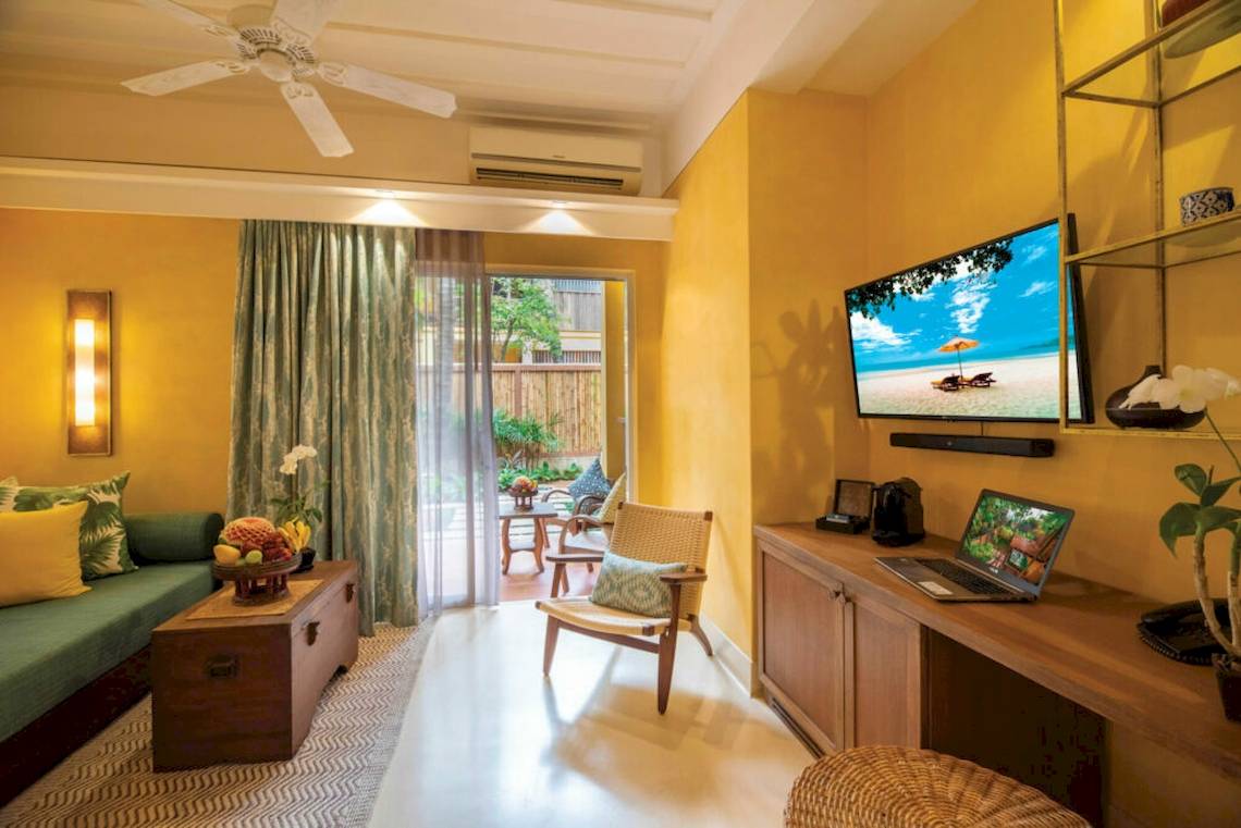 Hotelzimmer im Buri Rasa Village Samui mit Laptop, Fernseher und Balkon.