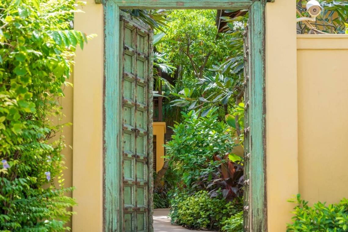 Offener grün gestrichener Türeingang zum Garten des Buri Rasa Village Samui