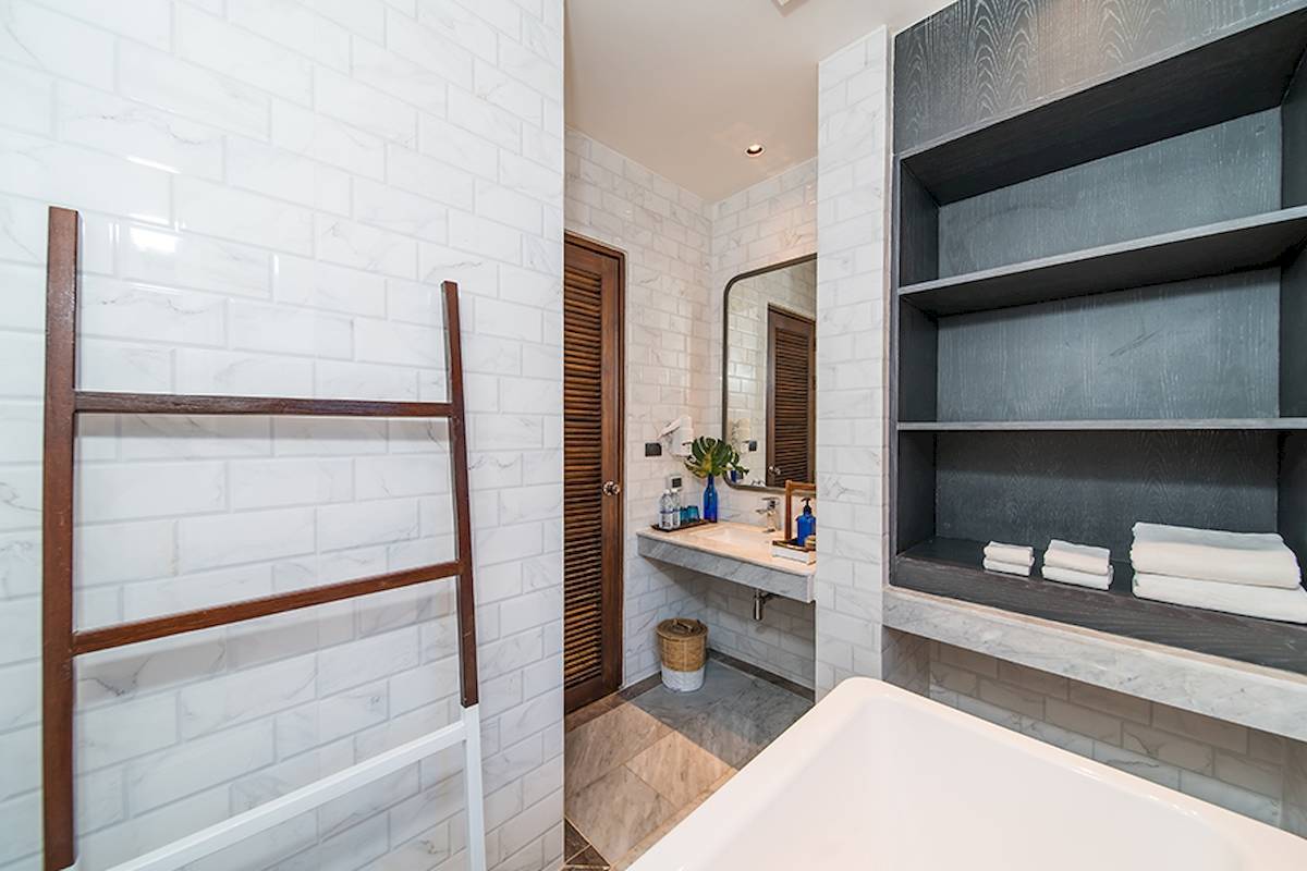 Badezimmer im Peace Resort mit Badewanne, Dusche, Toilettenpapierhalter und Regal mit Handtüchern.