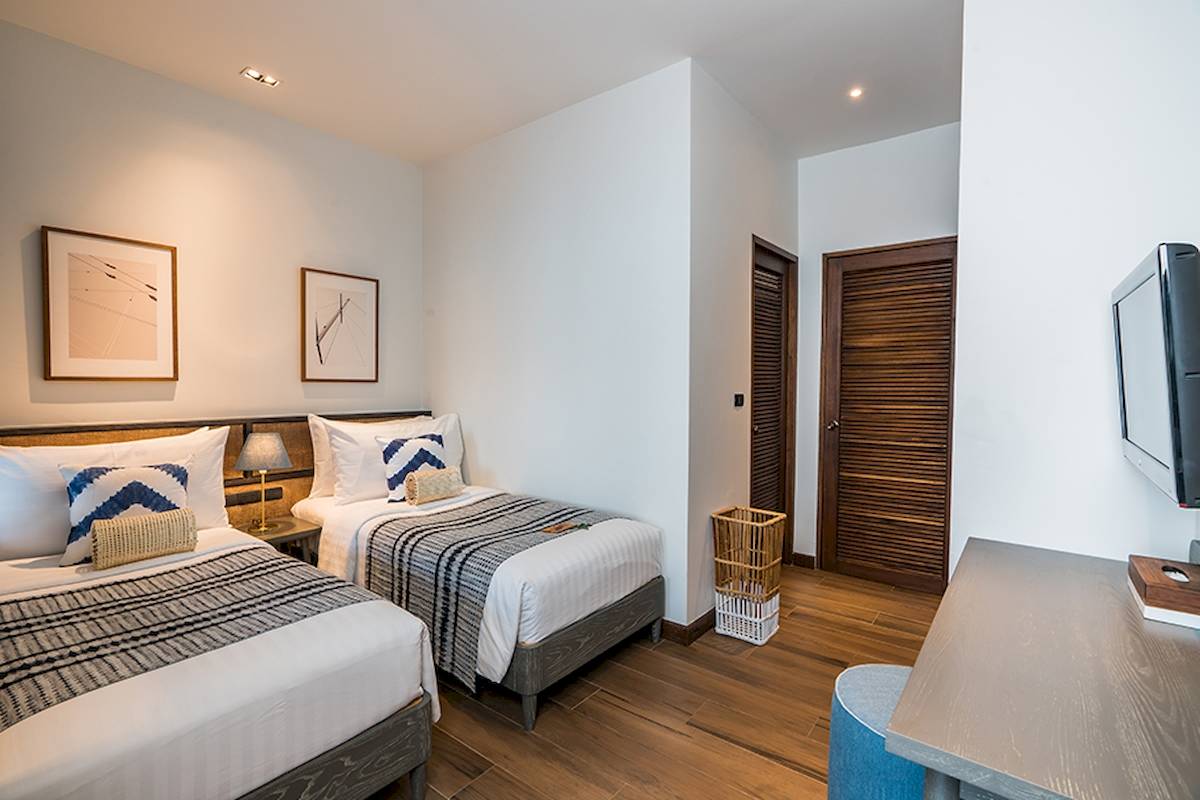 Doppelzimmer im Peace Resort mit zwei Betten, Dekor und Fernseher.
