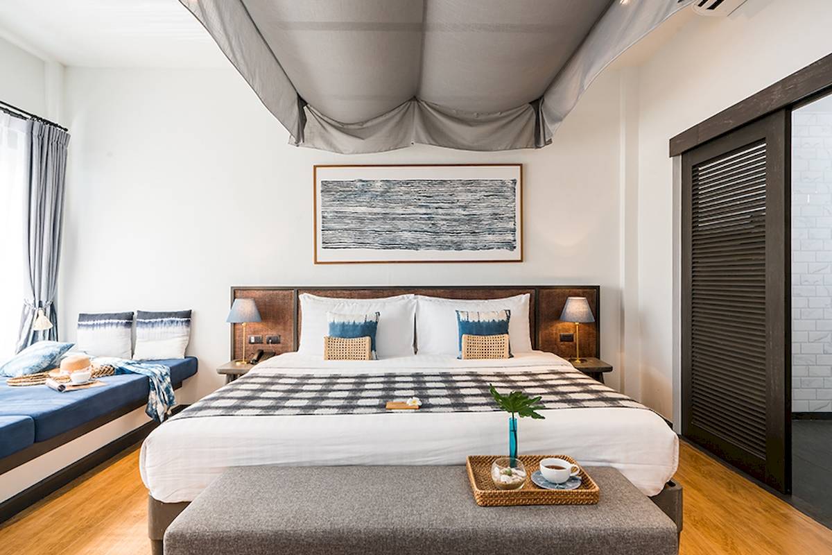 Schlafzimmer mit Doppelbett im Peace Resort, das eine ruhige und entspannende Atmosphäre bietet.
