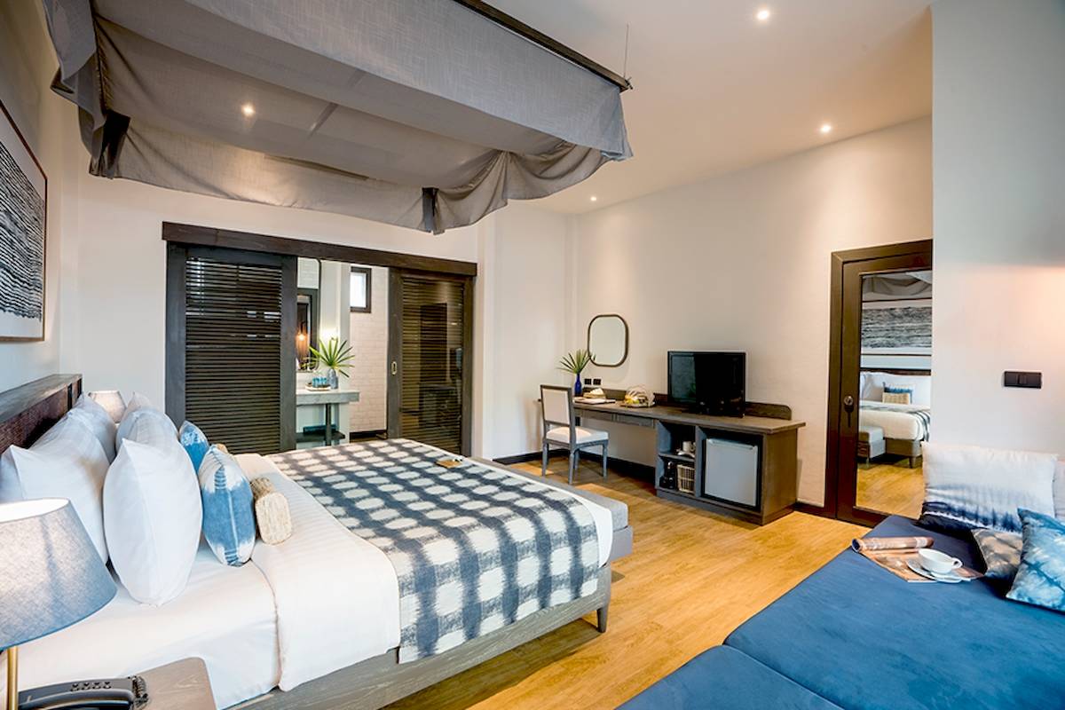 Schlafzimmer im Peace Resort mit einem großen Bett, einem Schreibtisch und einer Fernseher.