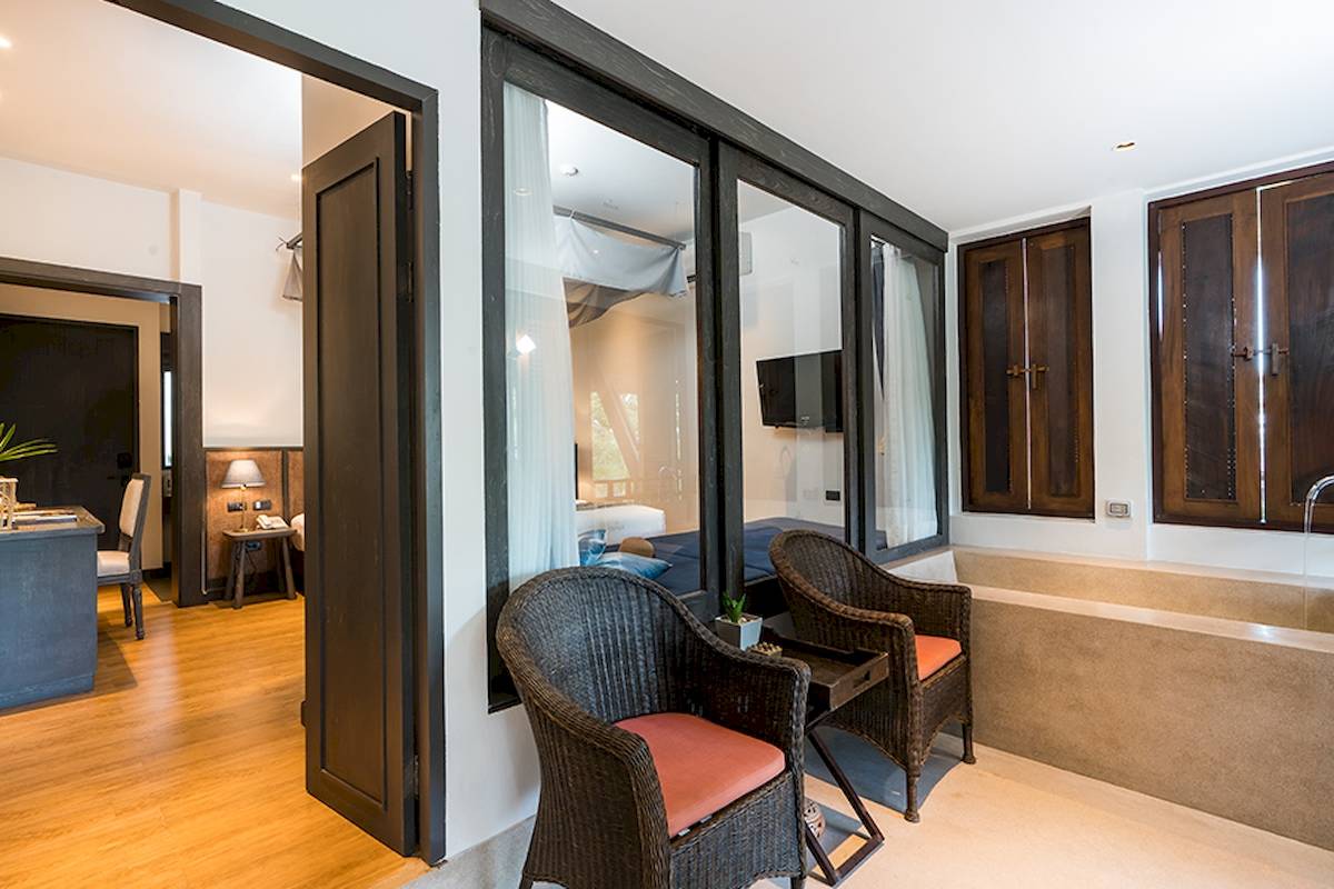 Innenansicht des Schlafzimmers im Peace Resort mit Bett, Fernseher und Badewanne.