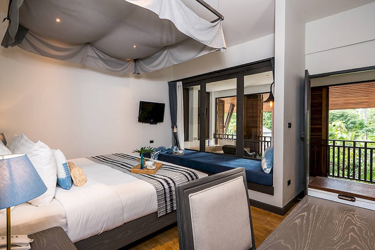 Schlafzimmer mit Bett, Balkon und Fernseher im Peace Resort