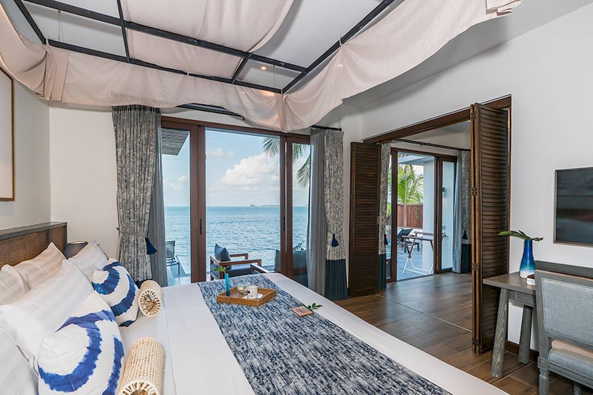 Schlafzimmer mit Meerblick im Peace Resort, mit einem großen Bett und einem Ausblick auf das Meer.