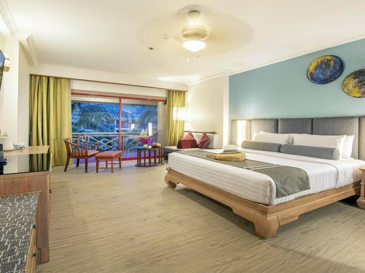 Hotelzimmer im Chada Thai Village Resort mit Bett, Balkon und Möbeln.