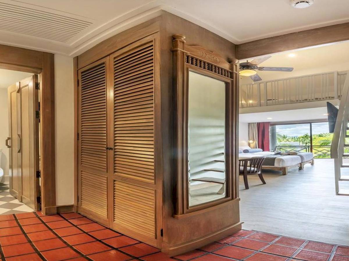 Zimmer im Chada Thai Village Resort mit rotem Boden und Holzschrank