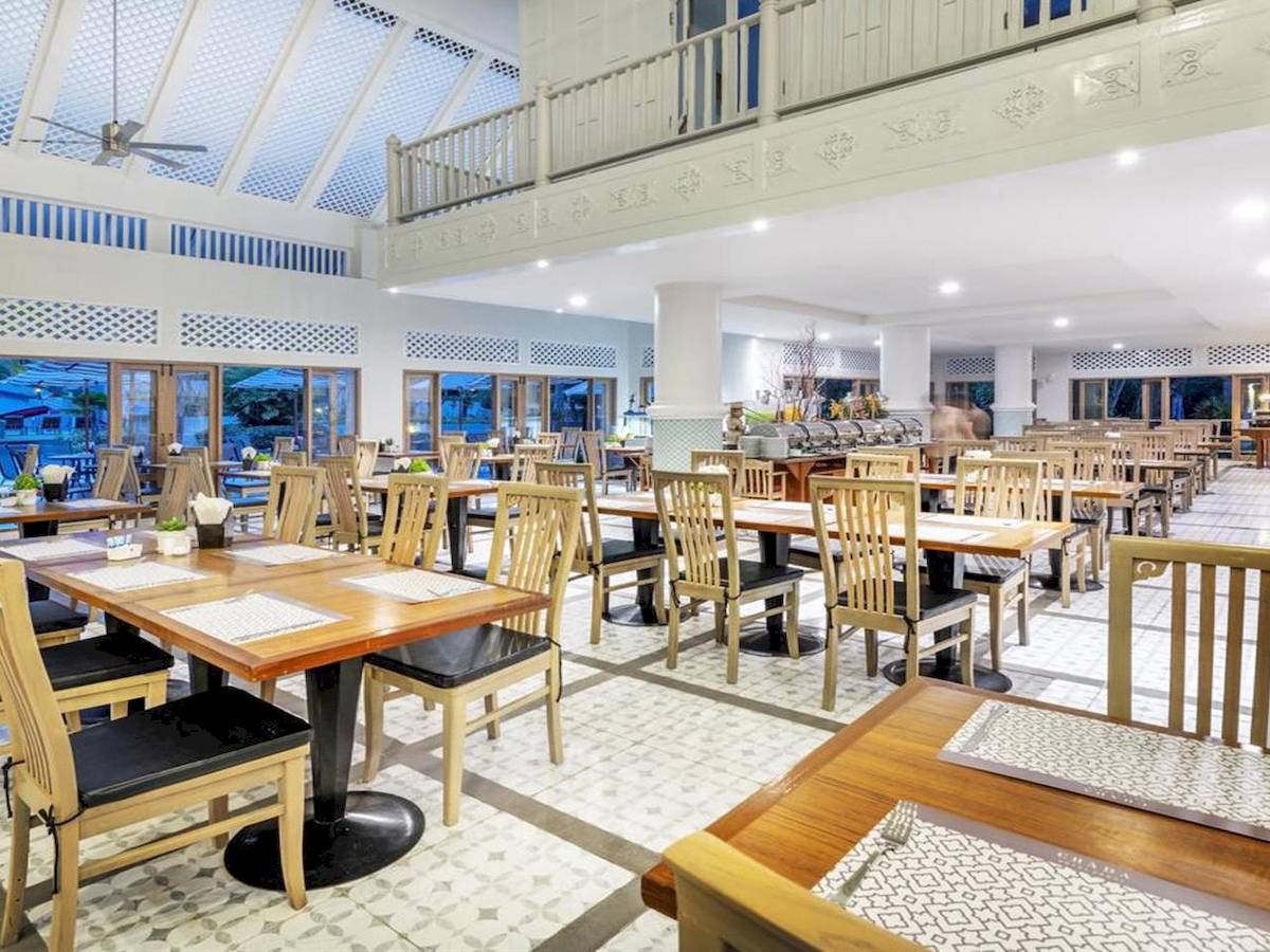 Restaurant im Chada Thai Village Resort mit modernen Möbeln und großen Fenstern.