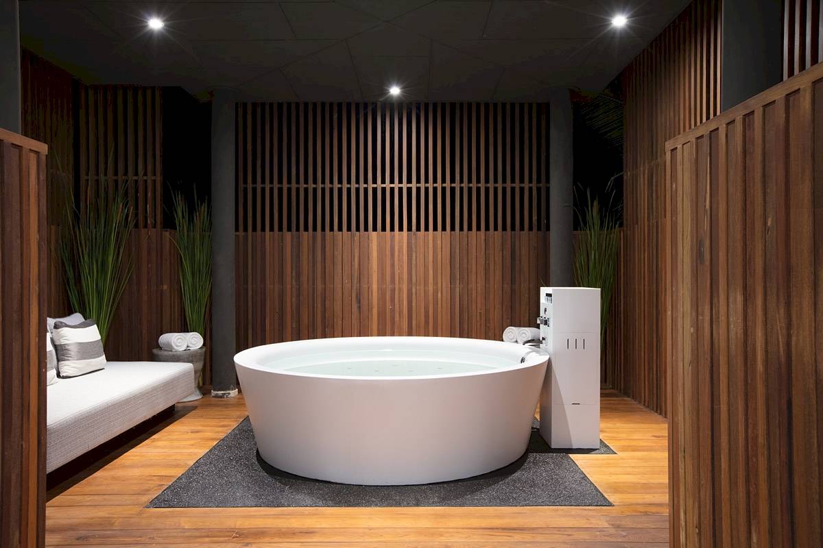 Innendesign des ShellSea Krabi Hotels mit einem großen weißen Badewanne und Holzwänden.