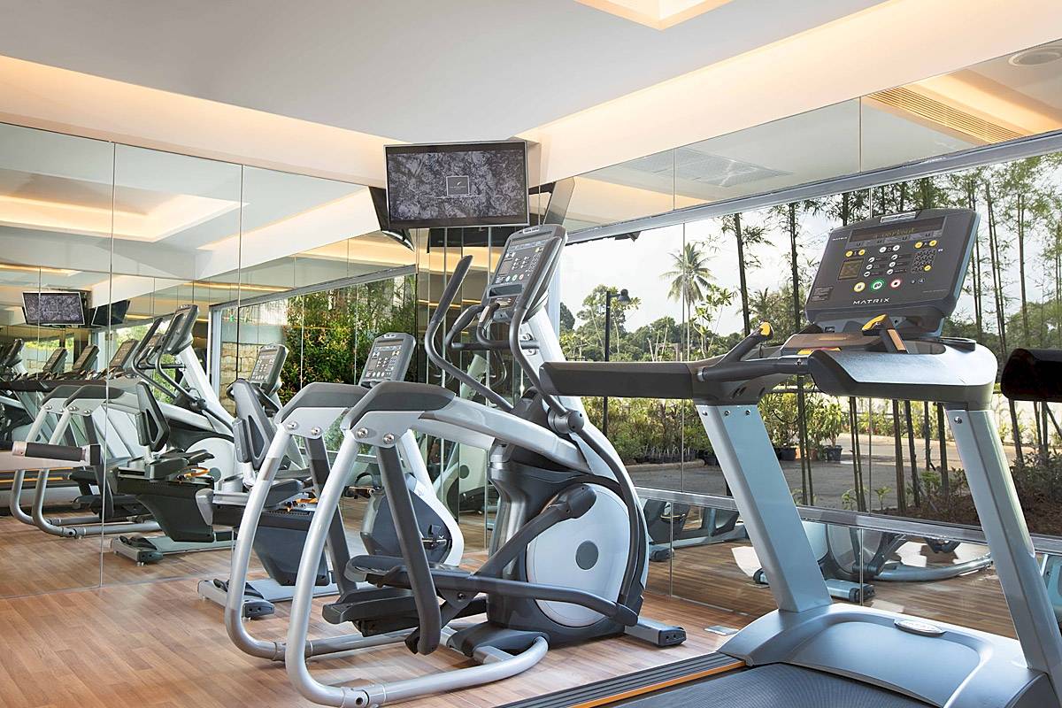Fitnessstudio im ShellSea Krabi Hotel mit mehreren Laufbändern und Spiegeln.
