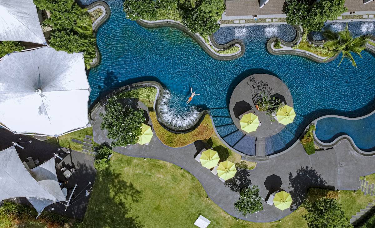 Aus der Vogelperspektive des ShellSea Krabi Hotel, Poolbereich mit Sprungturm und Sonnenschirmen.