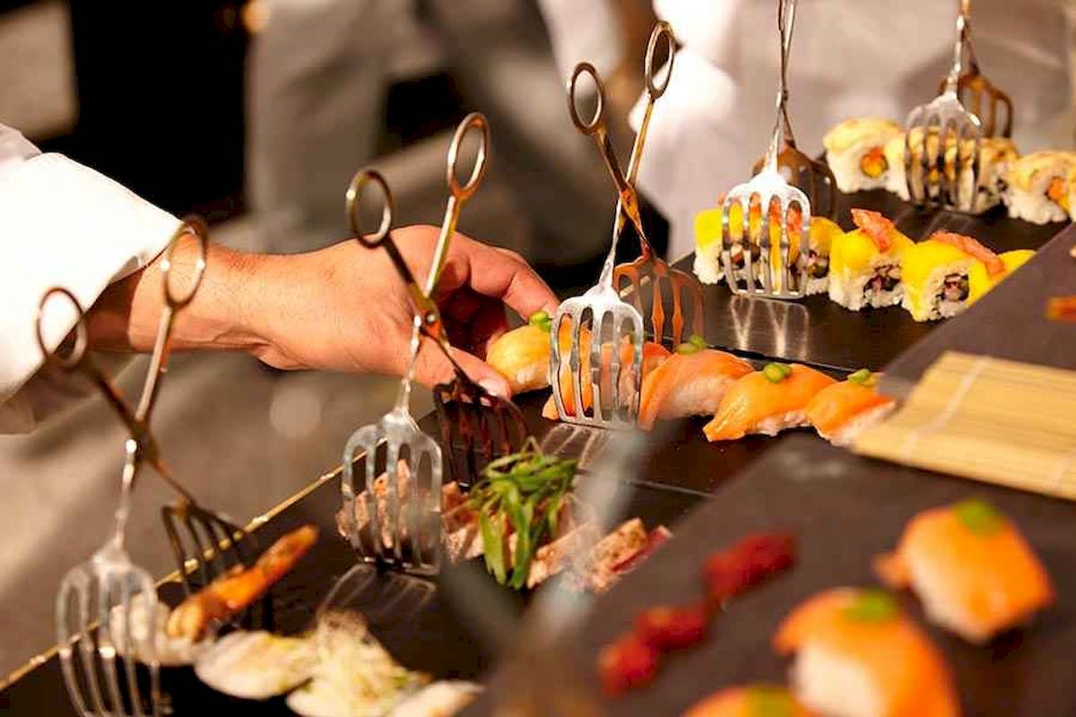 Sushi-Buffet im Riu Palace Costa Rica mit verschiedenen Gerichten, die mit Gabeln serviert werden.