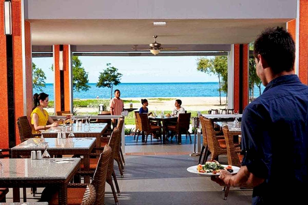 Terrasse des Riu Palace Costa Rica Hotels mit Blick auf das Meer und Gästen beim Essen.
