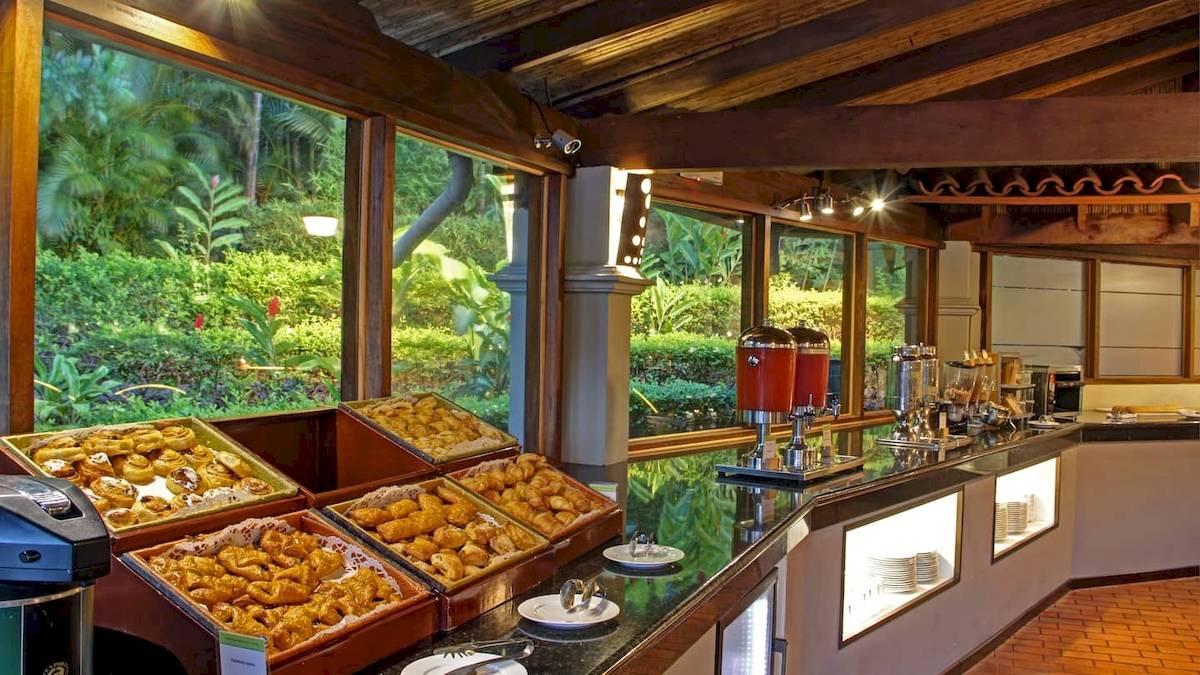 Frühstücksbuffet im DoubleTree by Hilton Hotel Cariari San Jose mit verschiedenen Gebäcksorten und Blick auf den Garten