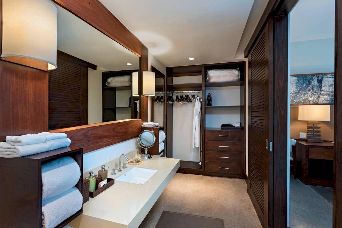 Badezimmer im El Mangroove, Autograph Collection Hotel mit Spiegel, Waschbecken und Kleiderschrank.