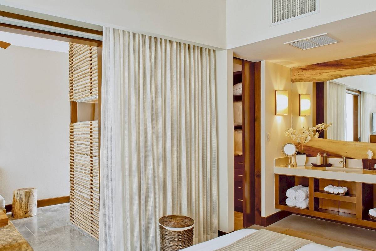 Innenansicht eines Badezimmers im El Mangroove, Autograph Collection Hotel, mit einem großen Spiegel und einem Waschbecken.