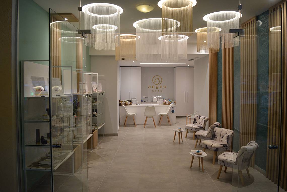 Innenbereich des Aegeon Spa mit modernen Möbeln, Glaswänden und runden Kronleuchtern.